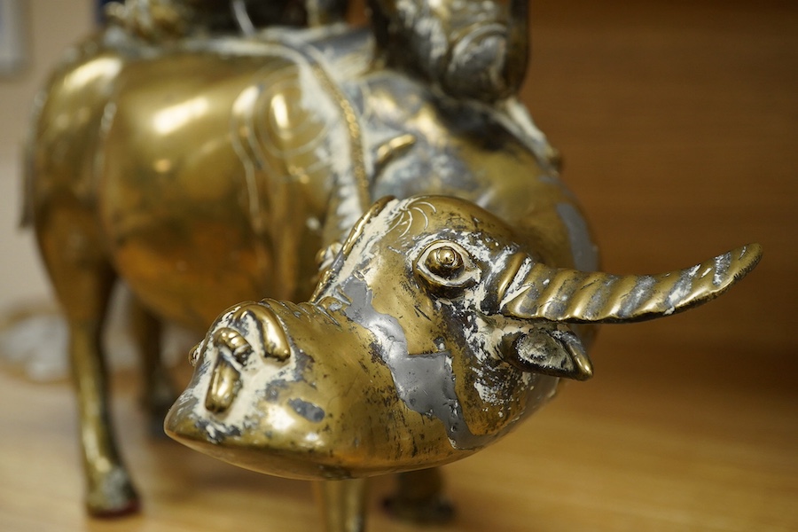A Chinese bronze and lead model of an ox with two riders, 25cm high. Condition - fair